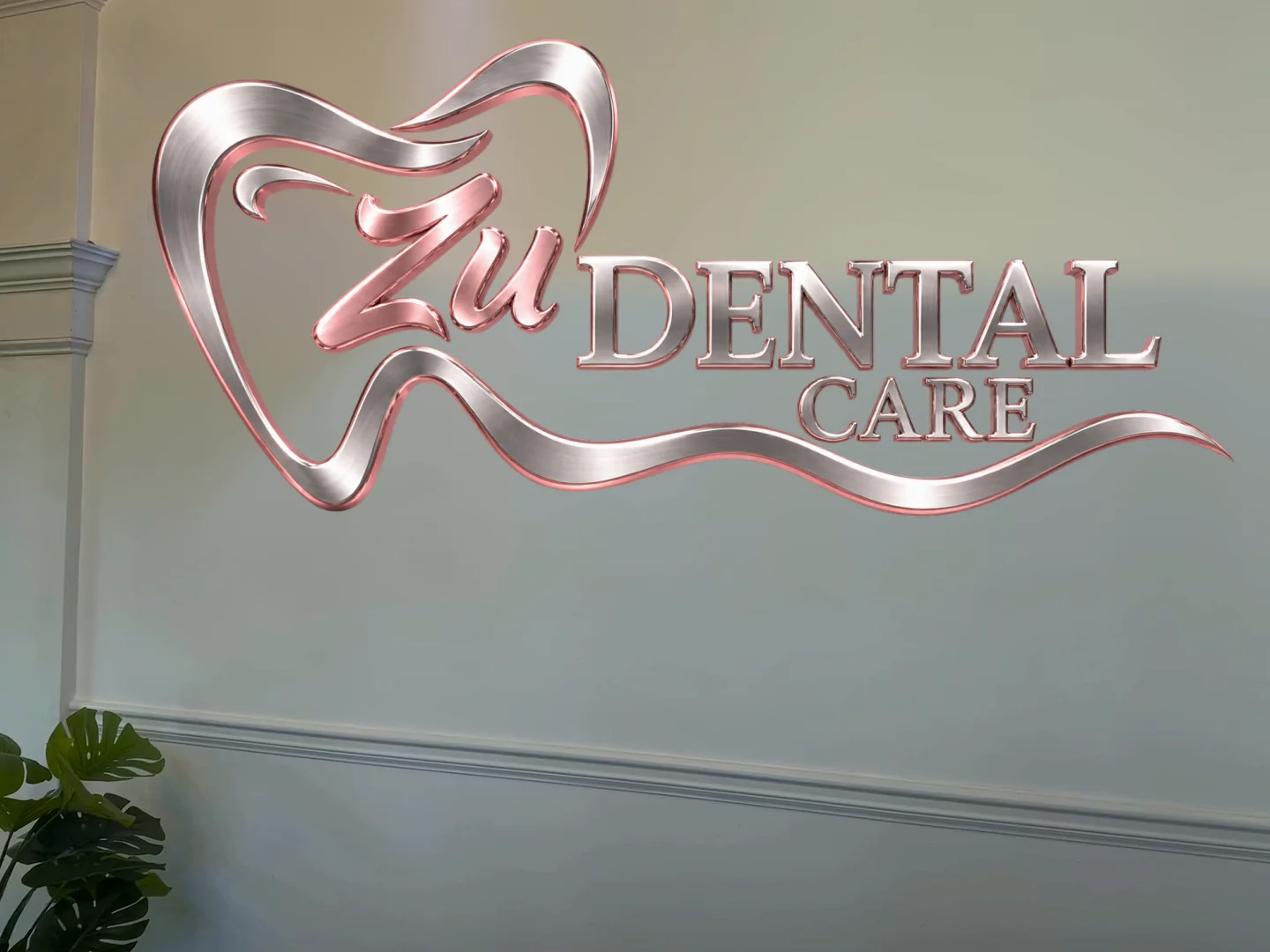 El logo de Zu Dental Care en plata y rosa sobre la pared de la recepción.